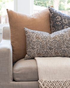 a couch with pillows on it in front of a window