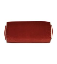 a red pillow with white piping on the top and bottom, in front of a white background