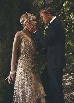 a man in a tuxedo standing next to a woman in a gold dress