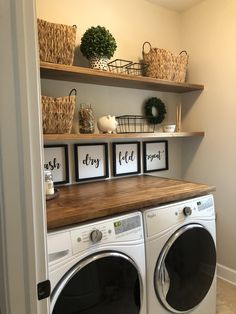 a washer and dryer in a room with open shelving on the wall