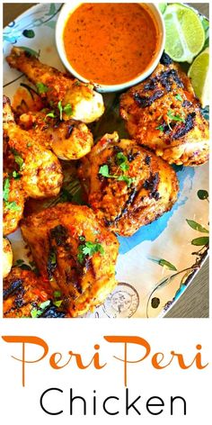 grilled chicken wings on a plate with dipping sauce and lime wedges for garnish