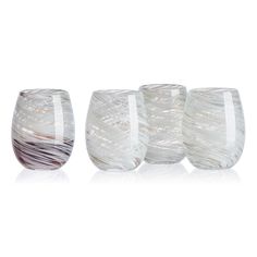 four wine glasses sitting next to each other on a white surface