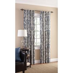 a living room with a couch, chair and window curtain in blue and white colors