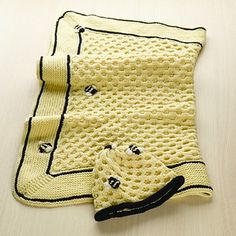 a yellow crocheted blanket on top of a wooden table