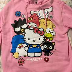 a pink hello kitty hoodie with cartoon characters on it