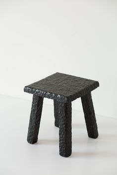 a black stool sitting on top of a white floor