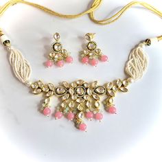 A bright gold and pink kundan necklace set with earrings. Can be worn as a choker or necklace. Pink Jewelry Sets For Diwali Party, Pink Temple Jewelry Sets For Celebrations, Pink Meenakari Jewelry Sets For Party, Pink Necklace For Diwali, Pink Kundan Choker For Festivals, Temple Style Pink Kundan Necklace For Festive Occasions, Pink Temple Jewelry Sets For Festivals, Pink Choker For Diwali Gift, Festive Pink Meenakari Choker