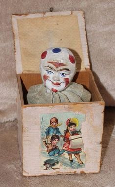 an old clown doll in a box with pictures on the front and back sides,