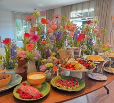 a table filled with lots of different types of food on plates and bowls next to each other