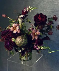 a vase filled with lots of flowers on top of a table