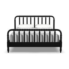 a black bed frame with white pillows on top of it and two side tables next to it