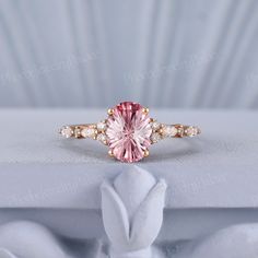 a pink diamond ring with three diamonds around it