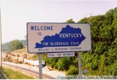 a welcome sign to kentucky on the side of the road