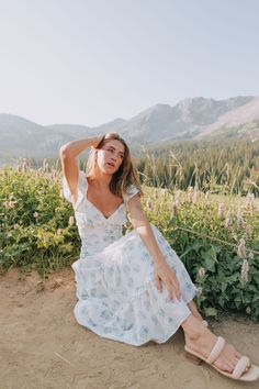 This exclusive Wisteria Lane dress is a playful and stylish addition to any wardrobe. The cream base is embellished with a delicate light blue floral print and embroidered details. The midi length and flutter sleeves add a touch of whimsy, while the decorative buttons, ruching, and ruffled tiers provide a flirty and feminine touch. Perfect for a day out in the sun or a special occasion. Details Cream dress with light blue floral print Cream embroidered details Nonfunctional buttons down front of Nursing Friendly Tops, Free People Sandals, Wisteria Lane, Nursing Friendly Dress, Plus Jumpsuit, Cream Base, Exclusive Dress, Embroidered Details, Maternity Shops