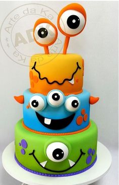 a three tiered cake with monster eyes on top