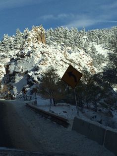 a road sign on the side of a snowy mountain