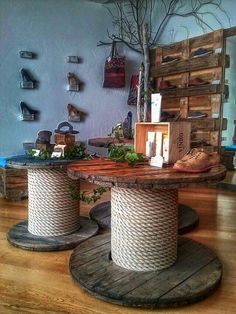 two round wooden tables with white rope wrapped around them on top of hard wood flooring