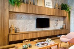 a living room filled with furniture and a flat screen tv mounted on a wall above a wooden coffee table