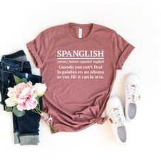 This SPANGLISH SHIRT is the best gift for ELA Teacher, English Spanish, Mexican American                                                      ⭐  HOW TO ORDER   ⭐  1-) Please check all the photos from the listing. 2-) Please choose your shirt size and color. (Shirt sizes are shown on the listing photos) 3-) Please choose your quantity. 4-) Click add to cart. If you would like to order more than one shirt, you can easily go back to the listing and do the same thing for the other shirts you would like to purchase. 5-) Then please click Proceed to checkout. You are all set !                                                    ⭐  FABRICATION  ⭐  ⭐⭐ Our product distrubutor BELLA + CANVAS  is well known for their soft, and comfy clothing.  Our solid colors are:  White Black Red Pink Kelly %100 rin Relaxed Fit Shirt With Funny Text For Gift, Spanish Teacher Gifts, Pink Kelly, Definition Shirt, Mexican Shirts, Graphic Tees For Women, Comfy Clothing, Ela Teacher, Spanish Teacher