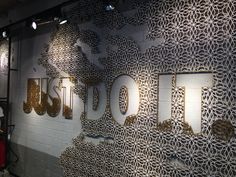 a wall that has some type of sign on it with gold letters in the middle