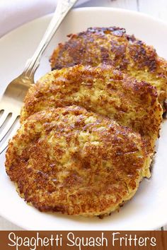 two fritters on a white plate with a fork