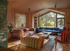 a living room filled with furniture and a painting hanging on the wall above it's windows