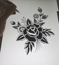 someone is drawing a flower with black ink