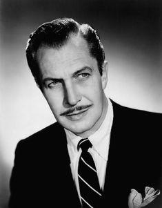 a black and white photo of a man in a suit with a moustache on his face