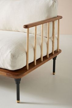 a wooden bed frame with white sheets on it