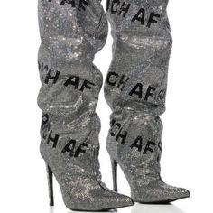 The Azalea Wang " Authentically A F " Rhinestone Knee High Boot In Silver Is A Sexy, Sparkly Faux Suede Boot Featuring A Slouchy Upper, Rhinestone Detailing Throughout, “Rich Af,” Rhinestone Text Print Patterning, And An Elasticated Knee-High Shaft. Complete With A Pointed Toe Silhouette, A Stiletto Heel, And A Pull On Fit. Wear This Statement Pair With Faux Leather Pieces For A Luxe Look. - Faux Suede Upper - Knee High Shaft - Pointed Toe - Stiletto Heel - 17.25” Shaft Height - 4.75” Heel Heigh Fitted Silver Boots With Rhinestones, Silver Fitted Rhinestone Boots, Glamorous Silver Winter Boots, Silver High Heel Boots With Rhinestone Fringe, Silver Embellished Boots For Night Out, Elegant Silver Boots With Rhinestone Fringe, High Heel Silver Boots With Bling, Silver High Heel Boots With Bling, Silver Sparkling Boots For Night Out