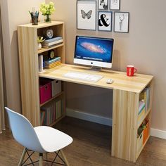 there is a desk with a computer on it and some pictures hanging above the desk