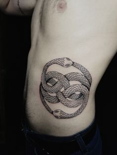 a man with a tattoo on his stomach that has an intertwined snake in the middle