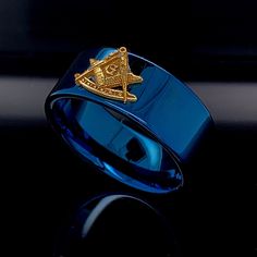 a blue ring with an masonic symbol on the front and side, sitting on top of a black surface