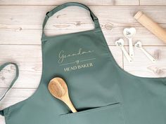 a green apron with a wooden spoon and some other kitchen utensils next to it