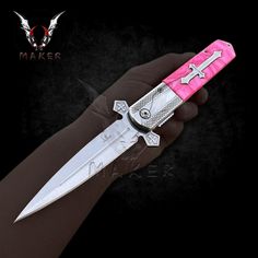 a person holding a pink and silver knife in their hand with an arrow on it