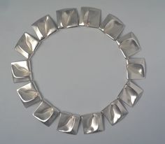 a close up of a silver bracelet on a white surface