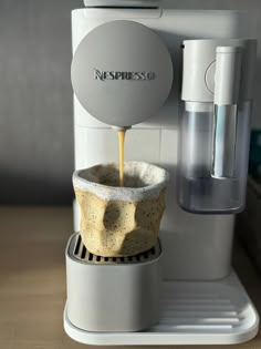 an espresso machine is pouring coffee into a cup