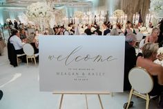 people sitting at tables in front of a sign that says welcome to the couple and their guests