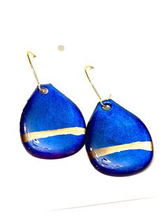 These light-catching teardrop earrings are made from black paper, handpainted with gold and a luminous blue-purple, coated with resin, and hung from gold-plated kidney wires.  Lightweight and versatile, they make a thoughtful gift or great addition to your own collection. Due to the nature of the paper, each pair of earrings will be unique.  Though the paper is sealed with resin, I'd recommend avoiding water and perfume. Materials: - paper - resin - gold-plated ear wire SEE MORE EARRING STYLES: -> Gorgeous, saturated colors: *Vivid Stains and Inks* https://www.etsy.com/shop/UnderSpaciousClouds?ref=seller-platform-mcnav§ion_id=26186462 -> Muted, multidimensional: *Color Washes* https://www.etsy.com/shop/UnderSpaciousClouds?ref=seller-platform-mcnav§ion_id=25907525 -> Lovely florals + metall Blue Teardrop Drop Earrings, Gold Hand-painted Teardrop Earrings, Blue Teardrop Earrings With Ear Wire, Gold Teardrop Earrings Hand Painted, Gold Hand Painted Teardrop Earrings, Blue Teardrop Pendant Earrings As Gift, Hand Painted Blue Teardrop Jewelry, Earring Styles, Bleu Violet