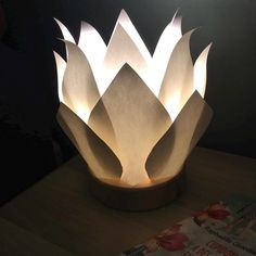 a light that is on top of a wooden table next to a book and magazine