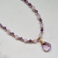 Amethyst Gemstone Necklace ~ Beautiful wire wrapped lavender teardrop faceted amethyst gemstone with purple and lavender faceted amethyst gemstone beads and gold square beads on 14k gold fill Figaro chain.  Amethyst pendant 13X19mm Adjustable 18.5-19.5" *Listing is for the necklace in the first photos ready to ship. SHOP~ http://www.etsy.com/shop/HanaMauiCreations?ref=si_shop International buyers please read our shipping policies before ordering~ POLICIES~ https://www.etsy.com/shop/HanaMauiCreat Teardrop Gemstone Beads For Gifts, Teardrop Amethyst Jewelry For Healing, Teardrop Amethyst For Jewelry Making, Lavender Natural Stones Jewelry For Meditation, Spiritual Teardrop Amethyst Jewelry, Lavender Gemstone Beaded Necklaces For Gift, Lavender Gemstone Beaded Necklaces As Gift, Lavender Gemstone Beads Necklace For Gift, Teardrop Amethyst Jewelry With Natural Stones