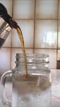 a glass jar filled with liquid being poured into it