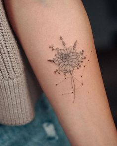 a woman's arm with a flower tattoo on the left side of her arm