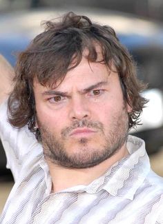 a close up of a person wearing a shirt and tie with his hand in the air