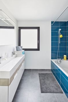 a bathroom with blue and white tiles on the walls, tub, sink and shower