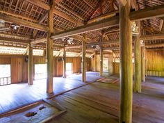 an empty room with wooden flooring and ceiling fanned in bamboo rafters on the roof