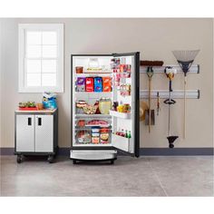 an open refrigerator in a kitchen next to a small cabinet with food items on it