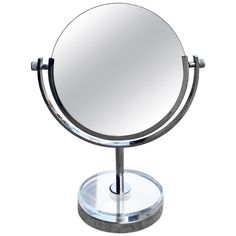 a round mirror sitting on top of a metal stand