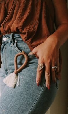 a woman with her hand on the back of her jeans and wearing an adjustable ring