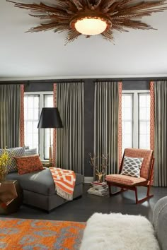 the living room is decorated in orange and gray tones with pops of color on the walls